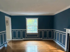 Interior painting project showcasing blue walls and white trim in a living room setting.