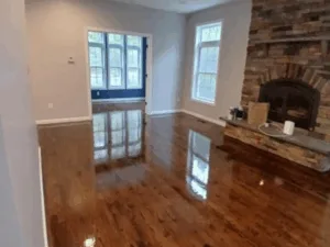 Hardwood floor refinishing in living room with fireplace