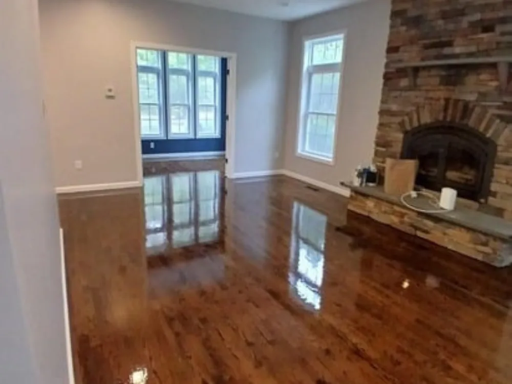 Hardwood floor refinishing in living room with fireplace