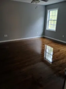 Freshly refinished wood floor in a gray room, with shiny surface.
