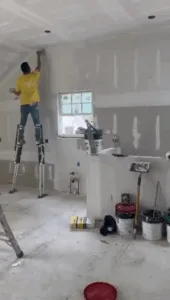 Drywall repair in progress before hardwood floor refinishing.