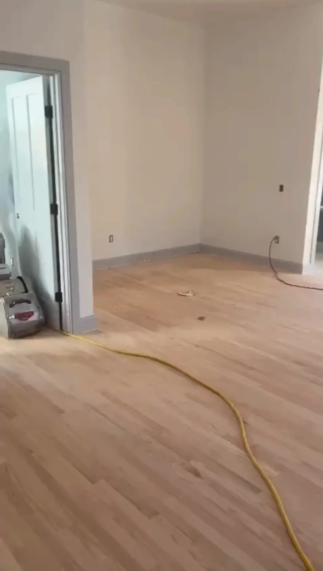 Hardwood floor refinishing preparation with sanding equipment.