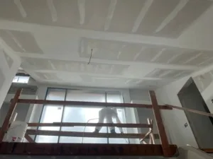 Kitchen drywall finishing with newly installed and taped ceiling drywall