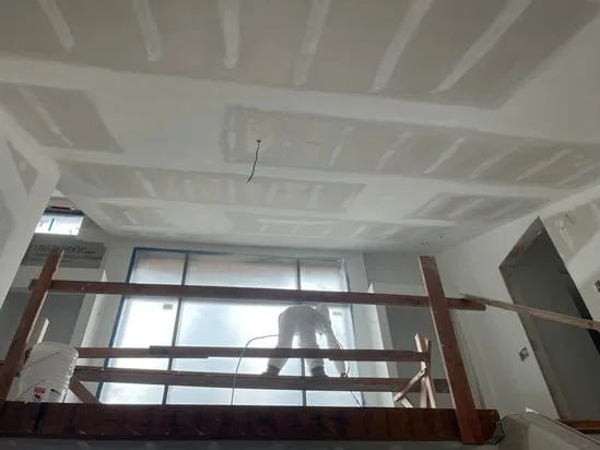 Kitchen drywall finishing with newly installed and taped ceiling drywall