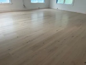 Wide-plank white oak floor finishing showcasing a smooth matte surface and light wood grain in a bright room.