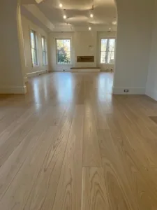 Completed hardwood floor repairs featuring a seamless finish and restored natural wood grain in a residential living space.