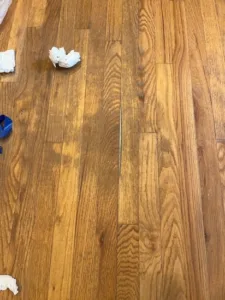A noticeable gap in the wood planks before we initiated the recent hardwood floor repair.